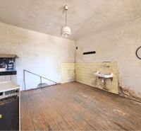 Interior of a family house with a wooden decor floor, old furniture, and a sink.