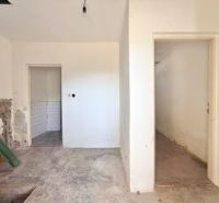 Unfurnished interior of a family house with older walls and doors.
