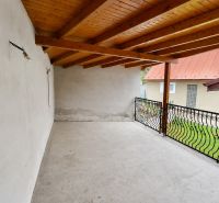 Covered terrace of a family house in Ochodnica with a wooden ceiling and wrought iron railing.