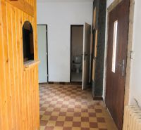 A hallway in a family house with checkered tiles and wooden wall panels.