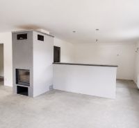 White room with a fireplace in a family house, floor with wooden decor.