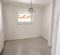 Interior of a family house with white walls and a window next to a light gray floor.