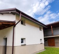 A family house in Ochodnica with a wooden shelter and a grassy area under the sky.