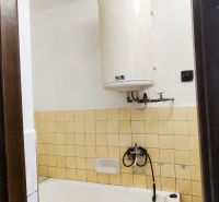 A bathroom in a family house with a bathtub and a gas boiler.