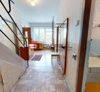 A hallway with a wooden decor floor and a bathroom in a family house.