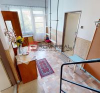A hallway in a family house with a decorative table and shelves, floor with a wooden decor.
