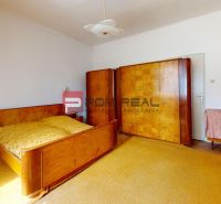 A bedroom in a family house with wooden furniture and carpet, floor with wooden decor.