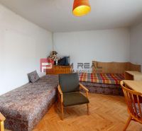 A room in a family house with a wooden decor floor, two sofas, and a table.