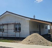 A family house in Bellova Ves under construction with scaffolding and a pile of sand.