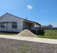 A family house in Bellova Ves with facade scaffolding and a pile of sand in the yard.