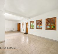 A spacious room with tiled flooring, white walls, and several wooden windows, Land - housing.