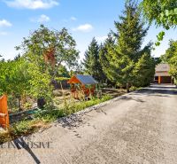 A reinforced driveway surrounded by greenery and a children's playground, an ideal location for living in Pezinok.
