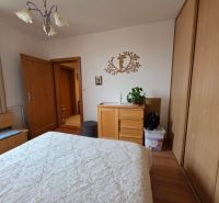 Bedroom in a 3-room apartment with a wardrobe and a wooden decor floor.