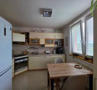 Kitchen in a 3-room apartment with a dining table and appliances.