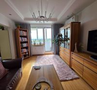 Living room in a 3-room apartment with a wooden decor floor and comfortable seating.