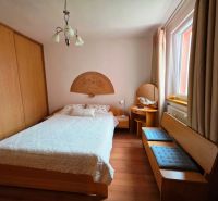 A bedroom in a 3-room apartment with a double bed, a built-in wardrobe, and a floor with a wood decor.