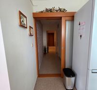 A hallway in a 3-room apartment with tiles and a decoration on the wall.