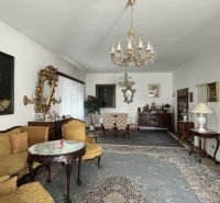 Interior of a villa with historical furniture, carpet, chandelier, and paintings in a classical style.