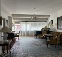 Living room of the villa with a Persian carpet, piano, and large windows.