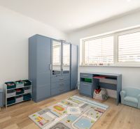 Children's room with blue furniture and a wooden decor floor in a family house.