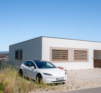 A family house in Trenčianske Jastrabie with a white vehicle on a gravel property.