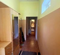 A hallway in a cottage with wooden decor furniture and a coat rack.