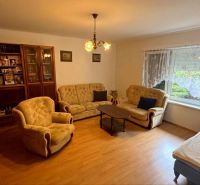 Living room in a cabin with sofas, armchairs, and a floor with a wooden decor.