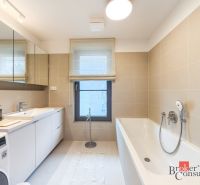 A bathroom in a 4-room apartment with a bathtub, sink, and washing machine.
