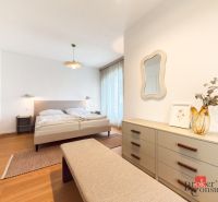 Bedroom in a 4-room apartment with a wooden decor floor and a large bed.