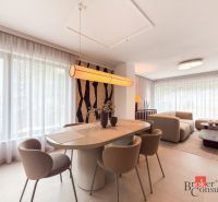 Dining area with a large table in a 4-room apartment, seating by the windows with curtains.