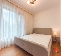Bright bedroom with wood-patterned flooring and a large window in a 4-room apartment.