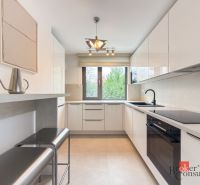 A bright kitchen with built-in appliances in a 4-room apartment with a wooden decor floor.