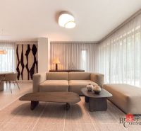 Living room in a 4-room apartment with a wooden decor floor, light furniture, and decorations.