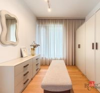 A wardrobe with a mirror, a closet, and a dresser in a 4-room apartment with a wooden decor floor.
