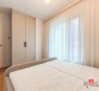 Bedroom in a 4-room apartment with a wardrobe, bed, and wooden decor flooring.