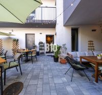 Outdoor gastro spaces in Bratislava - Old Town with tables and greenery.