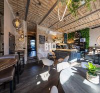 Interior of a gastro space with brick walls, wooden decor, and modern lighting.