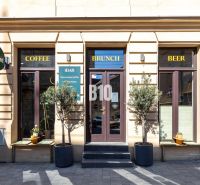 The exterior of a café and bar in Bratislava - Old Town with three entrances and signs.