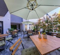 Outdoor dining areas in Bratislava - Old Town with wooden tables and umbrellas.