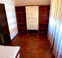 Bedroom in a 3-room apartment with a wooden decor floor and cabinets.