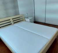 A bedroom in a 3-room apartment with a wood-patterned floor, white furniture, and lamps.