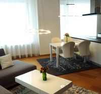 Living room in a 3-room apartment with a spacious kitchen and a wooden decor floor.