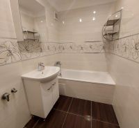 Bathroom in a 3-room apartment with a bathtub, decorative tiles, and a wooden decor floor.