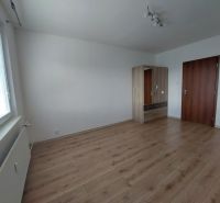 A room in a 3-room apartment with a wooden decor floor and a wardrobe.
