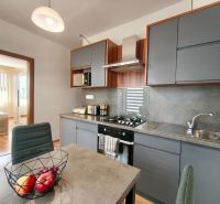 A kitchen in a 3-room apartment with a dining table and a modern kitchen unit.