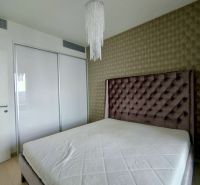 Bedroom in a 2-room apartment with a bed and built-in wardrobe, elegant wallpaper.