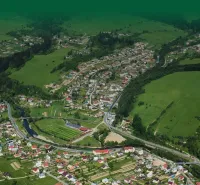 Aerial view of agricultural and forest land in Olešná with buildings and roads.