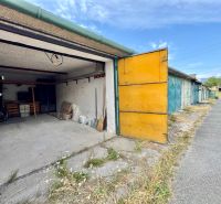 Open garage in Detva with a concrete floor and storage space.