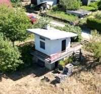 A cottage in Myjava surrounded by greenery with an access road and parking lot.
