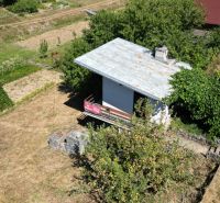 A cottage in Myjava with a garden surrounded by greenery and an outdoor grill.